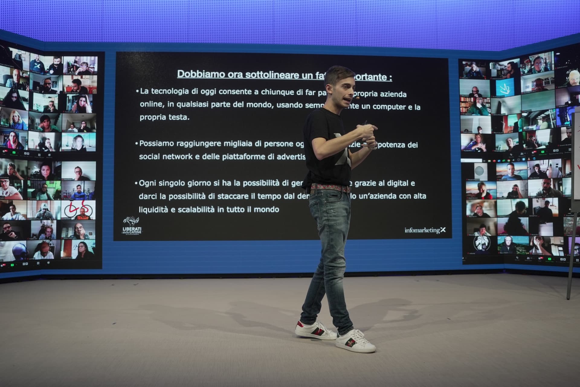 Vittorio durante una lezione live, sul palco davanti agli schermi con i partecipanti collegati